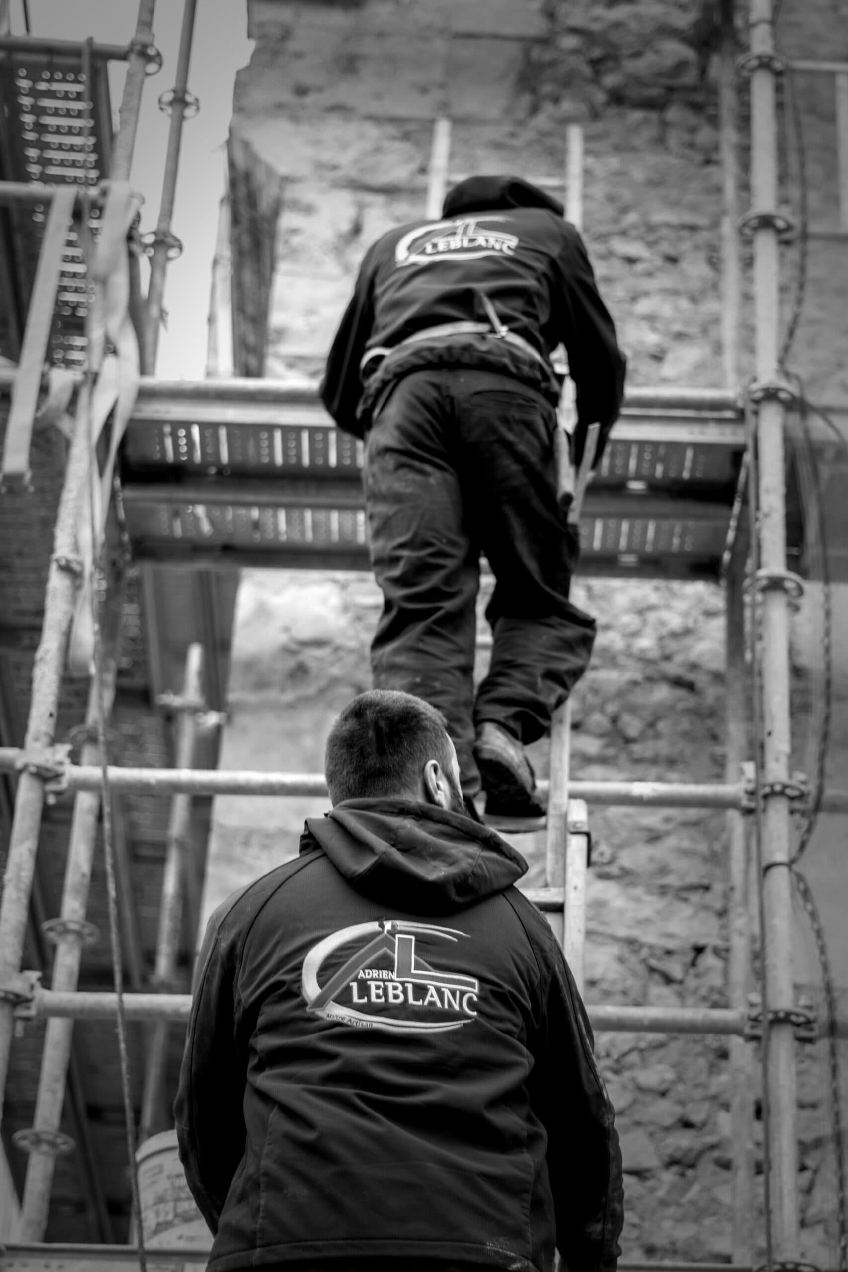 Deux membres de l'équipe de Adrien Leblanc grimpant une échelle